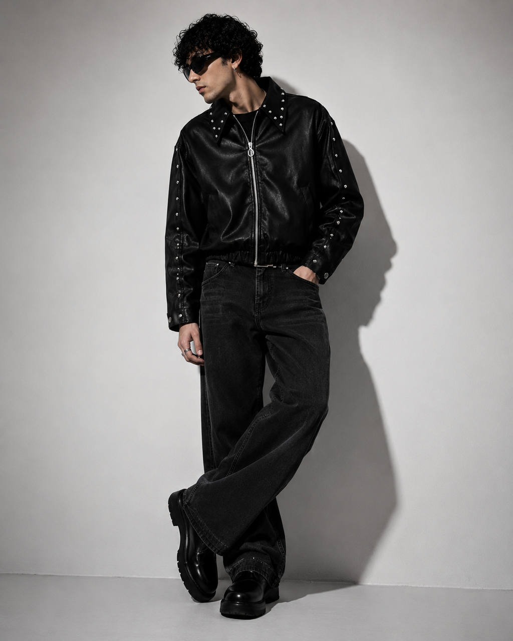 Male model wearing XOVRA Ironbite black cropped boxy fit studded jacket with oversized streetwear styling.