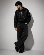 Male model wearing XOVRA Ironbite black cropped boxy fit studded jacket with oversized streetwear styling.